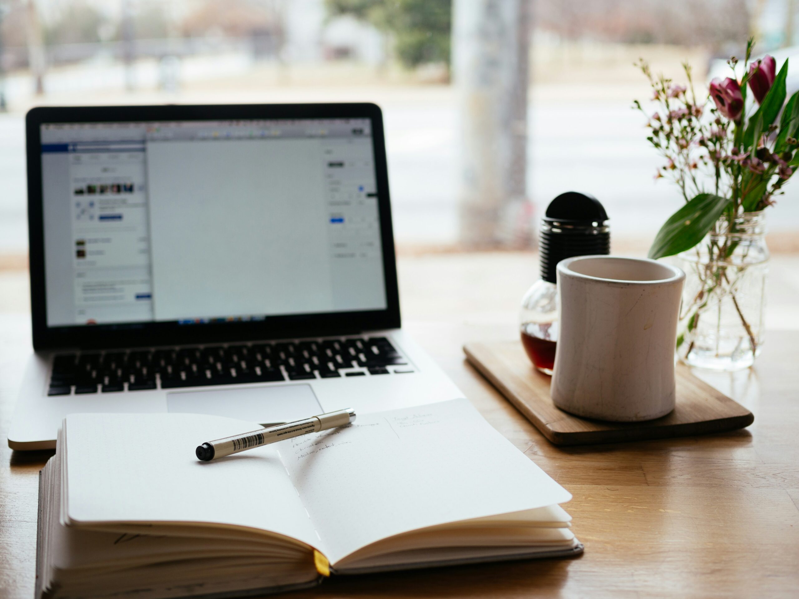 Laptop and notebook and coffee before writing an article